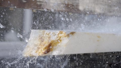 Macro Shot Of Makrana Marble Slab Being Cut With Water Spray In India. slow motion