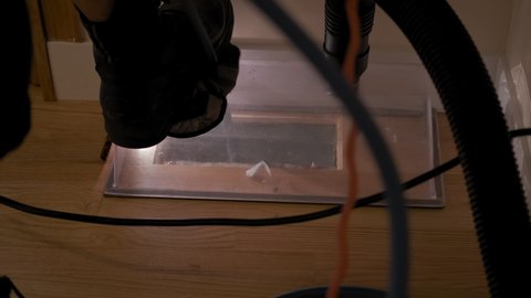 Close up view. Home Duct Cleaning Services, ventilation cleaner man at work with tool on the floor. Slow motion footage