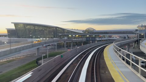 NEW YORK, USA - OCTOBER, 24, 2021: Riding airtrain in JFK airport terminal. Railroad, train driving on rail, approaching station. Monorail automatic car. Subway public transport. 