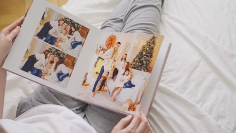 hands scroll through pages of photobook. family photo shoot. professional printing of photos and albums in printing, photo laboratory. photographer and designer services. memory.