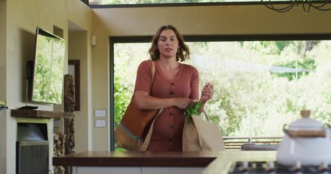 Tired caucasian pregnant woman returning home from shopping with heavy bag of vegetables. expecting baby and healthy lifestyle during pregnancy.
