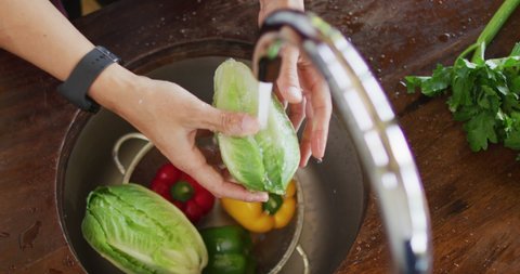 Hands of caucasian pregnant woman washing vegetables in kitchen. expecting baby and healthy lifestyle during pregnancy.