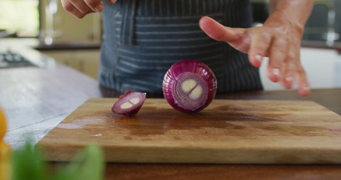 Hands of caucasian pregnant woman wearing apron and cutting onion. expecting baby, motherhood, cooking and healthy lifestyle during pregnancy.