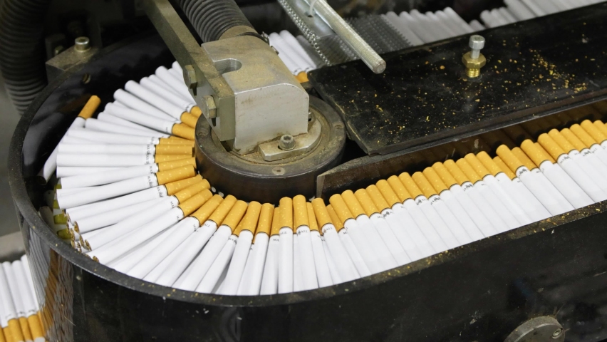 Cigarettes with a yellow filter move along the conveyor belt and there is a problem. This is a modern tobacco production. | Shutterstock HD Video #1086878924