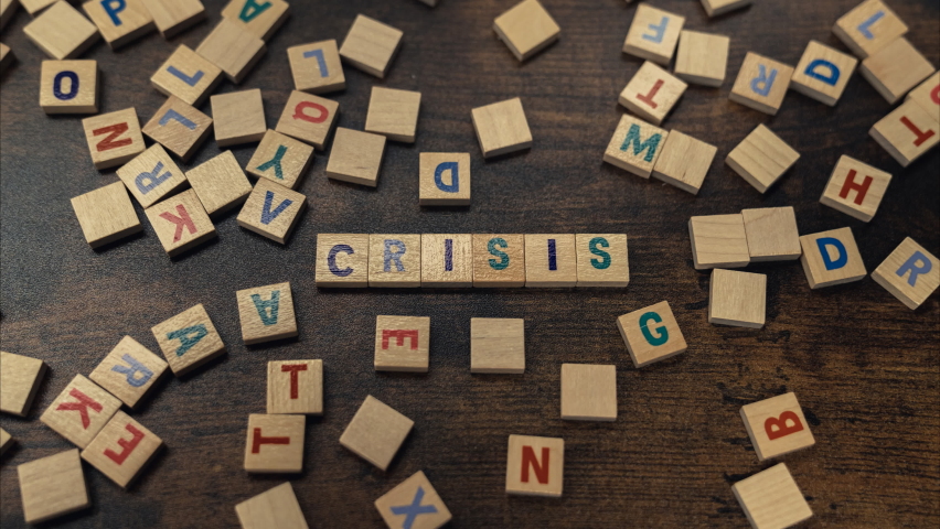 Crisis word gathered from wooden block letters - conceptual zoom in shot. High quality 4k footage