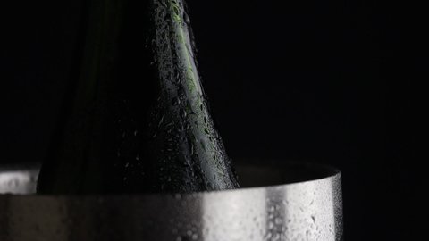 4k video of water droplets running down a chilled wine bottle and bucket. High quality water particles sliding down wine chiller for events and parties.