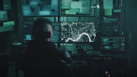 Zoom in view of anonymous man using illegal software on computer while spying on victims with associates. Conducts surveillance by determining the location and geolocation online virtual map