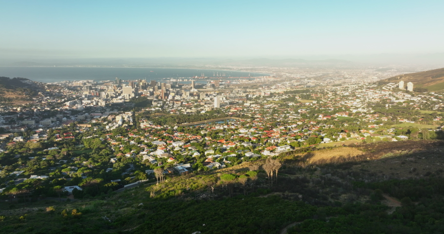 Aerial panoramic footage of town. Urban boroughs in City Bowl, sea bay with harbour in distance. Cape Town, South Africa