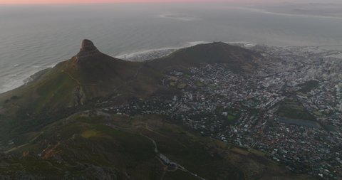 Aerial panoramic footage of city on ocean coast at twilight. Pink sky above horizon. Cape Town, South Africa