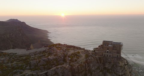 Aerial panoramic shot of famous tourist attraction at sunset. Backwards reveal of flat top of Table Mountain. Cape Town, South Africa
