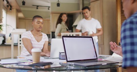 Group of diverse male and female friends working in kitchen on laptops with copy space. technology and communication, flexible working from home.
