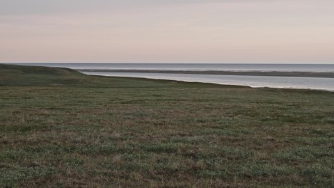 Panoramic view of sea and shore on Yamal peninsula. Faraway of people working on the shore.