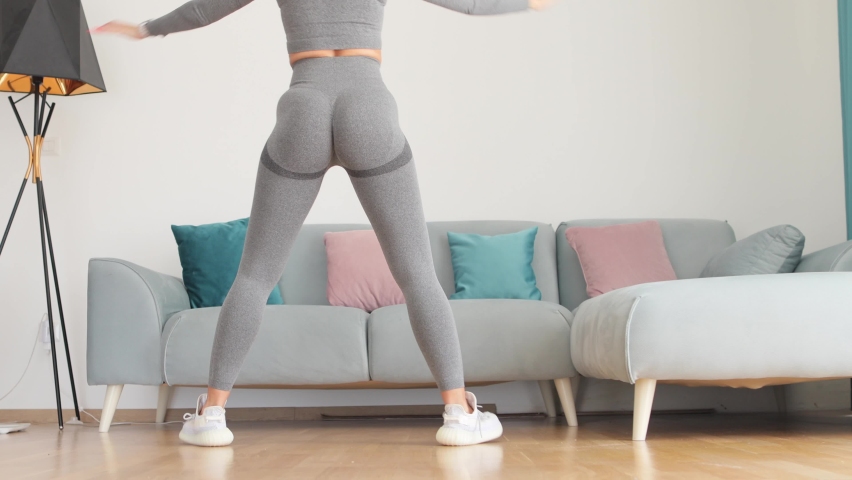 Female butt workout squats at home. Athletic Woman squats workout in living room. Female gymnastics. Glutes workout motivation. Fitness at home concept. | Shutterstock HD Video #1086898667