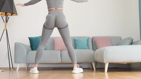 female butt workout squats at home. Athletic Woman squats workout in living room. Female gymnastics. Glutes workout motivation. Fitness at home concept. - Powered by Shutterstock - Get 15% off with code: PIKWIZARD15