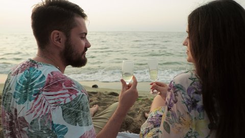 Date at sea at dawn Picnic Lovers drink champagne on the beach