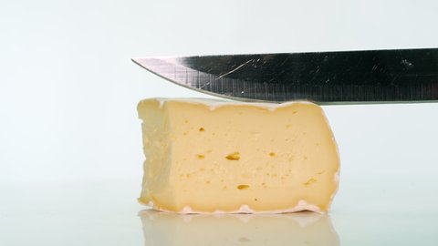 Cut with a knife Natural cheese on a white table, appetizing hard cheese with holes on a white backgroun