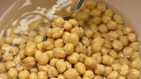 raw chickpeas pre-soaked for cooking, chickpeas soaked in water and swollen, close-up raw chickpea grains,