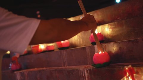 Select focus lotus candle light. A man's hand burn the incense joss stick