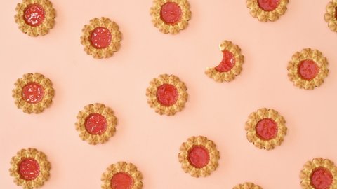 6k Pattern with sweet round biscuit cookies with orange glaze move on bright pastel orange background. Stop motion flat lay