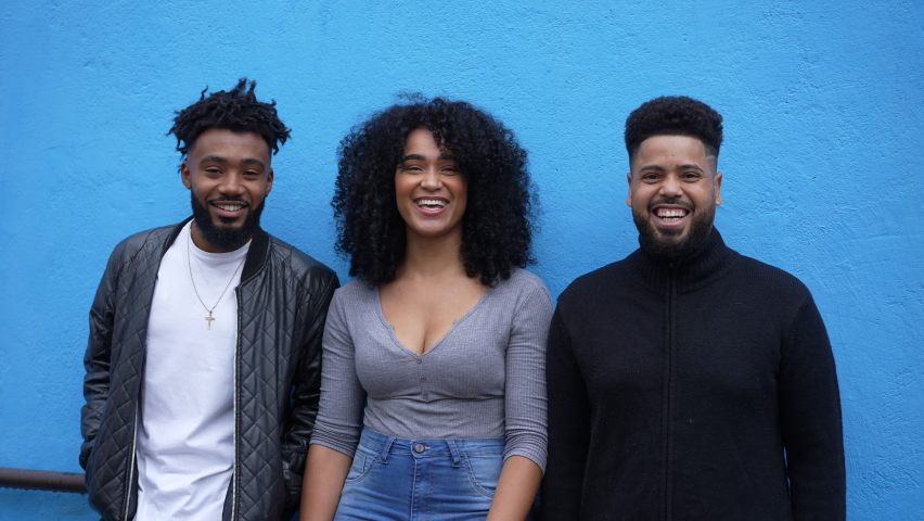 Happy friends leaning on blue wall hanging out together