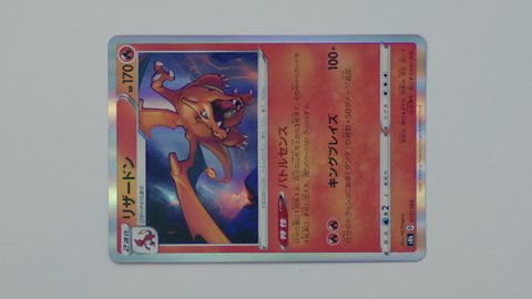 Hamburg, Germany - 01092022: video of the japanese pokemon card Charizard s8b 017 from the set Vmax Climax. Led light is moving over pokemon trading card to show the holo rainbow paper surface.