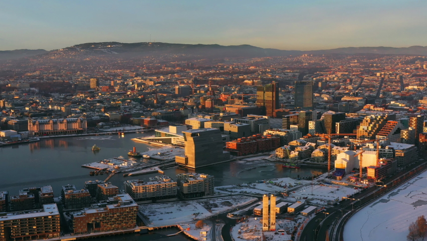 Oslo, Norway. Aerial view of Sentrum area of Oslo, Norway, with modern and historical buildings and car traffic. Grey sky in winter with snow, flying over Oslo