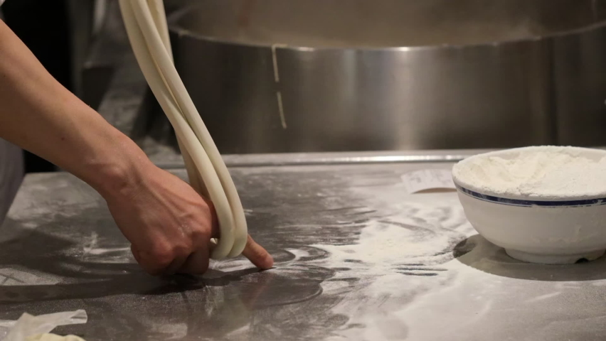 close up hands making hand-pulled Lamian Noodles. Traditional Chinese food. super slow motion Royalty-Free Stock Footage #1086919778
