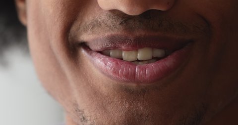 Close up moving mouth of teenage African guy, talking to camera, lower face part, front cropped view. Making speech, provide helpful information, share news, express opinion, public speaking concept