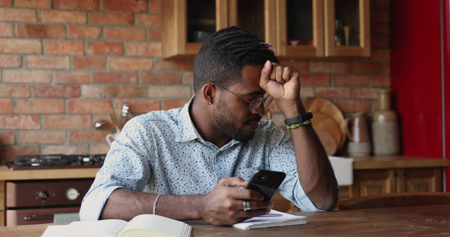 Annoyed angry millennial Black male hipster hold mobile phone feel outraged by low wifi internet signal bad connection application crash. Concerned worried young guy deal with software problem on cell Royalty-Free Stock Footage #1086926741