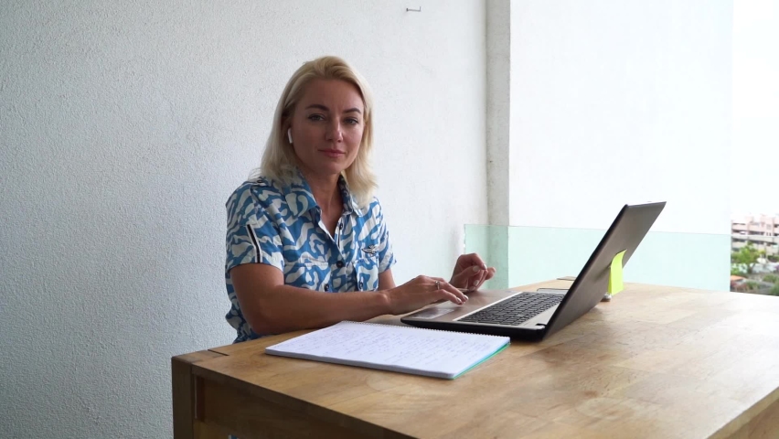 blond woman working or studing from home, busy woman wearing headphones using modern laptop computer, coronavirus pandemia working home life style