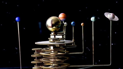 model of the solar system with a blurred sun on a black background of floating stars