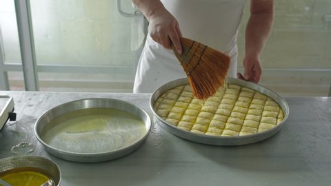 Process of cooking traditional turkish baklava pastry. Unidentified chef making thin filo dough for turkish pistachio dessert baklava