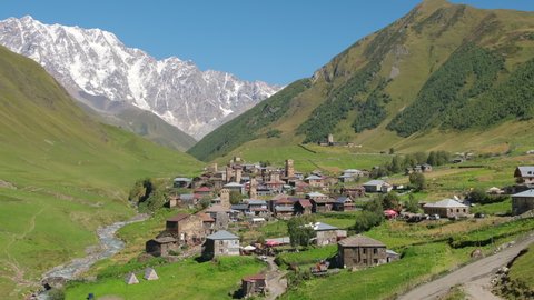 Beautiful landscape of the Ushguli village with Svan towers in Svaneti region in Georgia. Medieval stone tower houses with Caucasus Mountains at background. Slow zoom out
