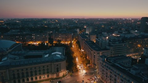 the sun sets over autumn bucharest. evening in a European city. urban active traffic in the old city - Aerial view 