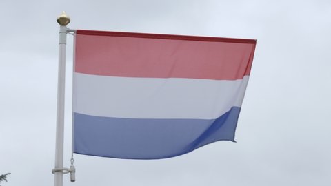 Ungraded: National flag of Netherlands on the flagpole. Dutch official flag waving in the wind. Ungraded H.264 from camera without re-encoding.
