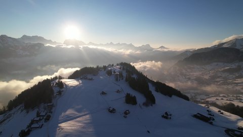 Stunning sunset over huge snowy mountain range in the alps, aerial rotate