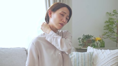 Asian female complaining of stiff shoulders