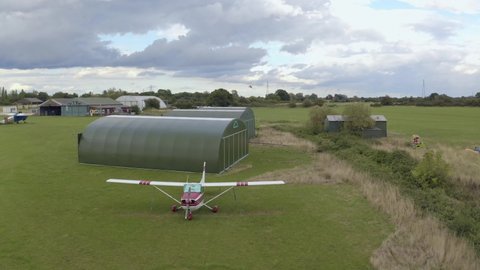 4K Gyrocopter landing pan with other plane in view near hangars