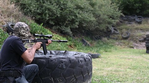 Side view of man shooting gun at range