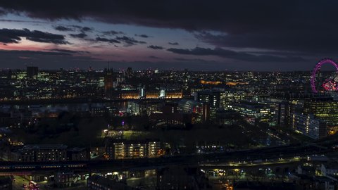 Establishing Aerial View Shot of London UK, United Kingdom, Palace of Westminster, British Parliament, at night evening, push back, last colors of sunset