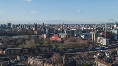 Establishing Aerial View Shot of London UK, United Kingdom, Palace of Westminster, British Parliament, following train, clear sky