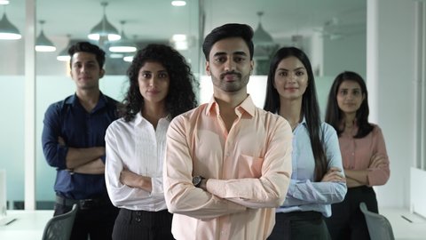 Happy Indian diverse business people office workers team standing in row looking at camera. Multiethnic professional employees executives group posing together for corporate portrait leadership.