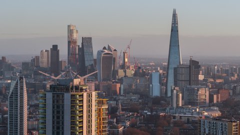 Cinematic, slow right, Establishing Aerial View Shot of London UK, United Kingdom, City of London and skyscrapers, early morning light