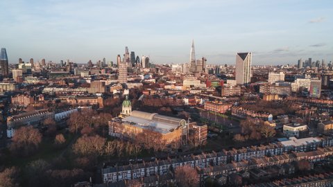 Establishing Aerial View Shot of London UK, United Kingdom, City of London and skyscrapers, slow push in, nice soft clouds in sunny day, golden hour,
