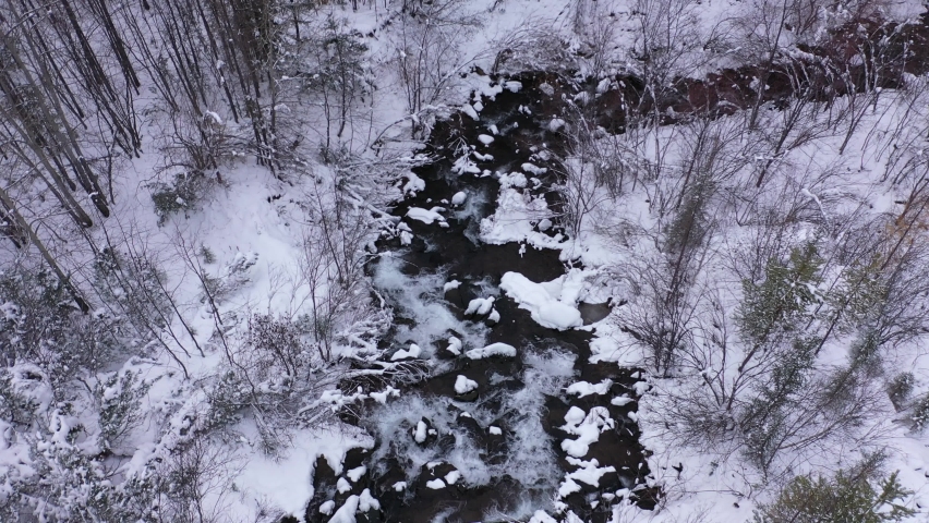 Stream and waterfall in winter among the snows in the taiga. 