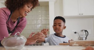 Animation of stay natural text over happy african american mother and son cooking at home. family, togetherness, health and wellbeing lifestyle concept digitally generated video.