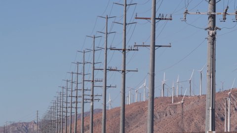Windmills turbine rotating, wind farm power plant, alternative green renewable energy generators, industrial field in California desert USA. Electricity generation on windfarm. Palm Springs, Coachella