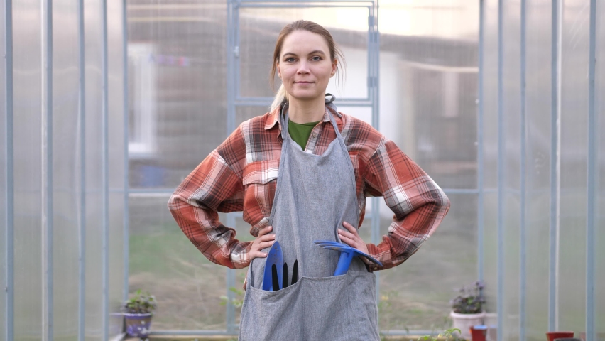 Female farmer owner working in vegetables hydroponic farm with happiness. Young woman is crossing arm and looking at camera with smile and happiness in the green house farm.