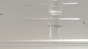 Detail video of water running of a stainless steel counter top towards the drain, in slow motion