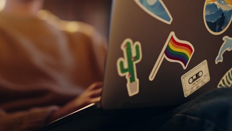 Close Up Footage of Person Using Laptop Computer with Diverse LGBT and Lifestyle Stickers on the Back. Creative Designer Typing on Keyboard, Browsing Internet and Checking Social Media.